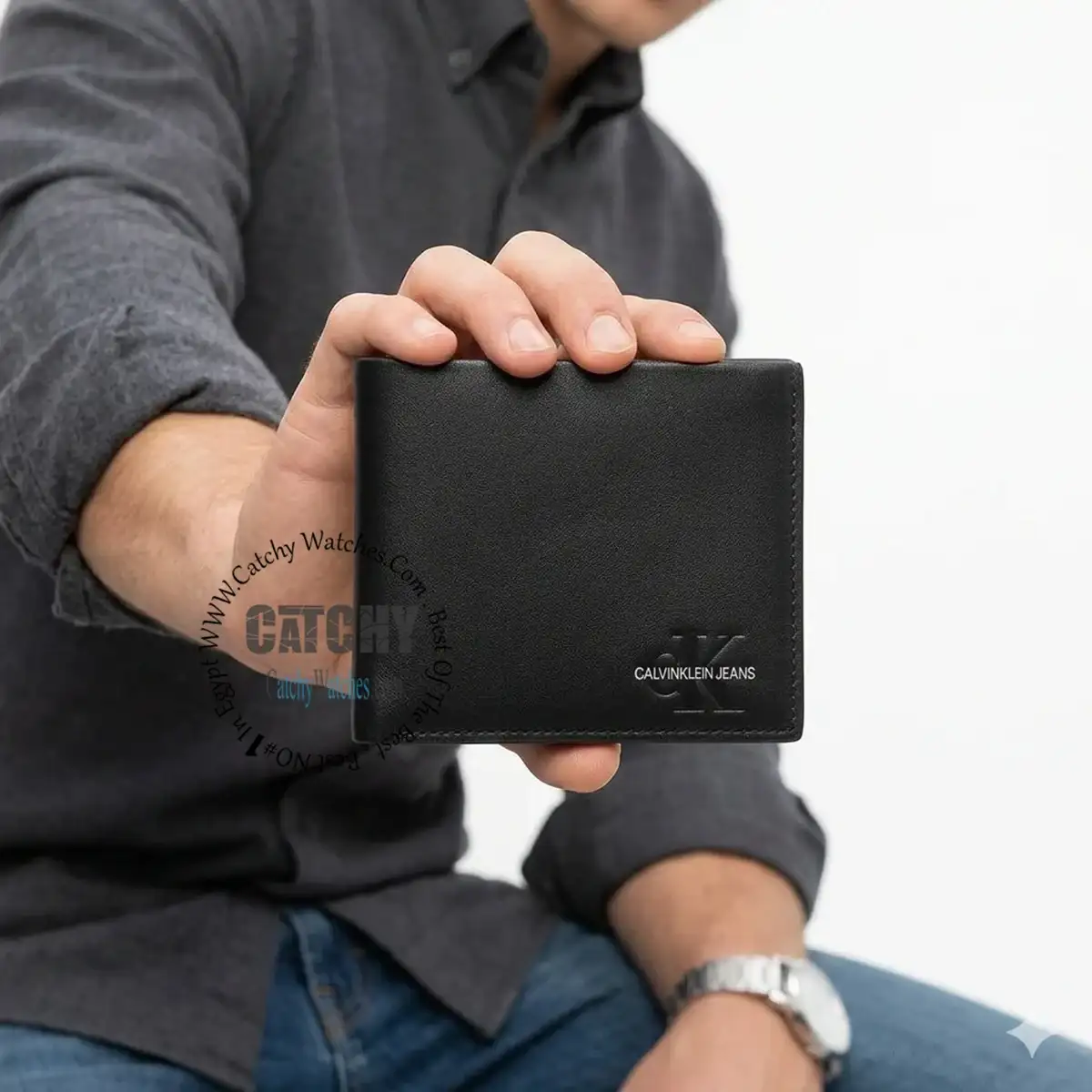 Man in a dark shirt holds a black leather wallet facing the camera, showing a subtle CK Jeans logo on the lower right corner.