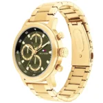 Gold-tone stainless steel chronograph watch with green dial and three subdials, Hilfiger branding, metal bracelet.