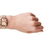 ar11347-emporio-armani-watch-square-women-rose-gold-dial-mesh-stainless-steel-metal-rose-gold-strap-quartz-battery-analog-gioia_40 Rose gold rectangular wristwatch with a metal mesh band on a person's left wrist, showing a simple dial.