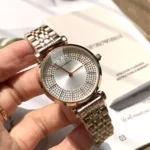 Silver Emporio Armani wristwatch with a crystal-studded dial held in a hand.