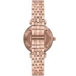 Rose-gold metal wristwatch photographed from behind, showing a multi-link bracelet and crown.