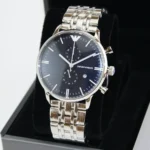 Silver metal wristwatch with a black dial and Emporio Armani logo, displayed in a black presentation box.