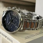 Stainless steel Emporio Armani chronograph watch with a dark blue dial, placed on its white box.