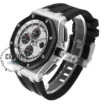 Silver and black chronograph wristwatch with a black rubber strap and hexagonal screws on the bezel, viewed at an angle