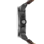 Side view of a wristwatch with a textured dial, crown, and brown leather strap.