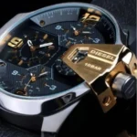 dz7377-original-diesel-watch-balck-leather-strap_3 Close-up of a Diesel men's watch with a dark textured dial, gold-tone indices and hands, and a prominent gold-tone crown lever showing 10 BAR water resistance note in view of the face.
