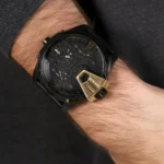 dz7377-original-diesel-watch-balck-leather-strap_5 Black Diesel chronograph watch on a wrist with a gold-toned protective cover and black strap, showing multiple dials and markers.