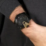 dz7377-original-diesel-watch-balck-leather-strap_7 Black Diesel wristwatch on a man's wrist with a dark multi-dial face and a gold-tone shield accent.
