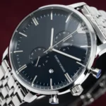 Close-up of a stainless steel Emporio Armani chronograph watch with a black dial, three subdials, and date window.