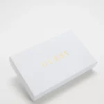 White rectangular Guess packaging box with gold logo, angled on a white background.