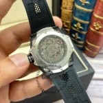 Back view of a limited edition skeleton watch showing its exposed movement with pink jewels, mounted on a black rubber strap.