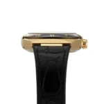 omega-constellation-co-axial-master-chronometer-41-mm-leather-strap-automatic_4 Gold wristwatch with black alligator-embossed strap, side view showing crown and slim gold case.