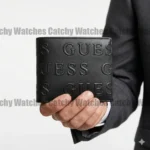 Black leather wallet with a raised GUESS logo pattern held by a hand in a suit jacket; watermark across image.