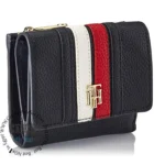 original-tommy-hilfiger-wallet-women-navy-blue-genuine-leather_2 Compact black crossbody purse with white and red stripes and a gold logo accent, angled to show textured leather surface