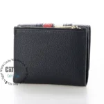 original-tommy-hilfiger-wallet-women-navy-blue-genuine-leather_4 Compact black textured leather wallet with a zippered top coin pocket, shown in a side view
