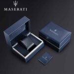 Blue Maserati gift box set with an open inner box displaying a navy leather belt; includes a matching outer box and a small Maserati booklet.
