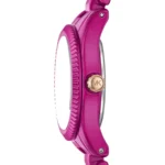 Side view of a bright pink wristwatch with a knurled bezel and gold crown labeled VK.