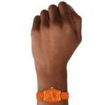 Bright orange wristwatch on a dark-skinned hand with a metal link band and round dial.