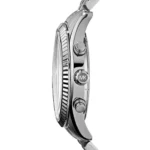 mk8280-michael-kors-watch-men-blue-dial-metal-stainless-steel-silver-strap-quartz-battery-analog-chronograph-lexington_5 Close-up side view of a shiny silver wristwatch with a textured bezel and crown marked 'MK' on the side.