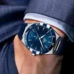 Blue Omega wristwatch on a man's wrist with a blue dial, silver case, and blue strap.