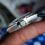 Close-up of a silver smartwatch/watch crown with a circular 'C' mark on the side of a polished metal case.