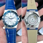 Omega Constellation wristwatch with blue strap; front: white dial, blue hands, Roman numerals.