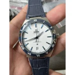 Omega Constellation Co-Axial Master Chronometer wristwatch with white dial, blue hands and markers, blue bezel with Roman numerals, date at 6, and a blue leather strap.