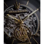 Close-up of a skeleton watch movement in gold and steel, featuring the Maserati logo and intricate gears.