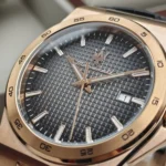 r8851153001-original-maserati-watch-men-black-dial-leather-strap_11 Close-up of a gold-tone wristwatch with a textured black dial, gold hands, and a date window at 3 o'clock.