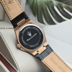 r8851153001-original-maserati-watch-men-black-dial-leather-strap_12 Rose-gold wristwatch with a black circular case back bearing the Maserati logo and text, attached to a tan genuine leather strap.