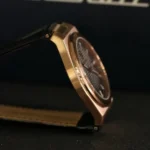 r8851153001-original-maserati-watch-men-black-dial-leather-strap_19 Close-up side view of a gold-toned wristwatch with a black strap, showing the case and crown.