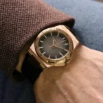 r8851153001-original-maserati-watch-men-black-dial-leather-strap_20 Rose-gold wristwatch with a black leather strap on a man's wrist, textured dark dial and date window