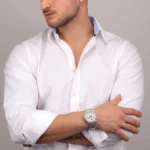 r8853142005-maserati-watch-men-silver-dial-metal-stainless-steel-strap-quartz-battery-analog-three-hand-100m-330ft-stile_6 Man in a white button-down shirt with sleeves rolled, arms crossed, wearing a silver wristwatch on the left wrist.