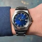 Stainless steel wristwatch with a blue textured dial and a date window on a metal link band.