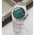 Stainless steel wristwatch with a green textured dial and date display, resting on a marble surface.