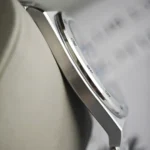 Close-up of a stainless steel watch bezel with engraved numerals, viewed at an angle.