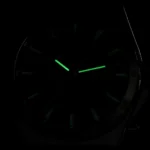 Analog clock face in darkness with luminous green hour and minute hands visible.