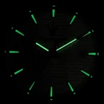 Close-up of a black analog clock with luminescent green hands and hour markers in darkness.