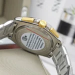 Close-up of a two-tone stainless steel watch with a gold crown and bracelet, viewed from the side.